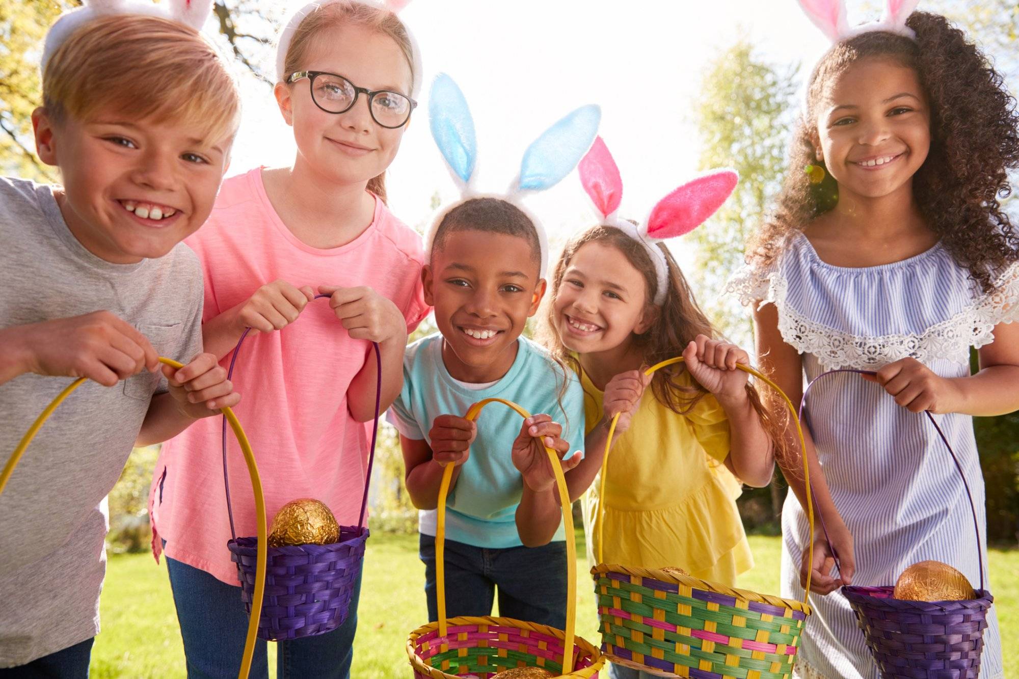 Portrait Of Five Children Wearing Bunny Ears On Easter Egg Hunt In Garden Portrait Of Five Children Wearing Bunny Ears On Easter Egg Hunt In Garden