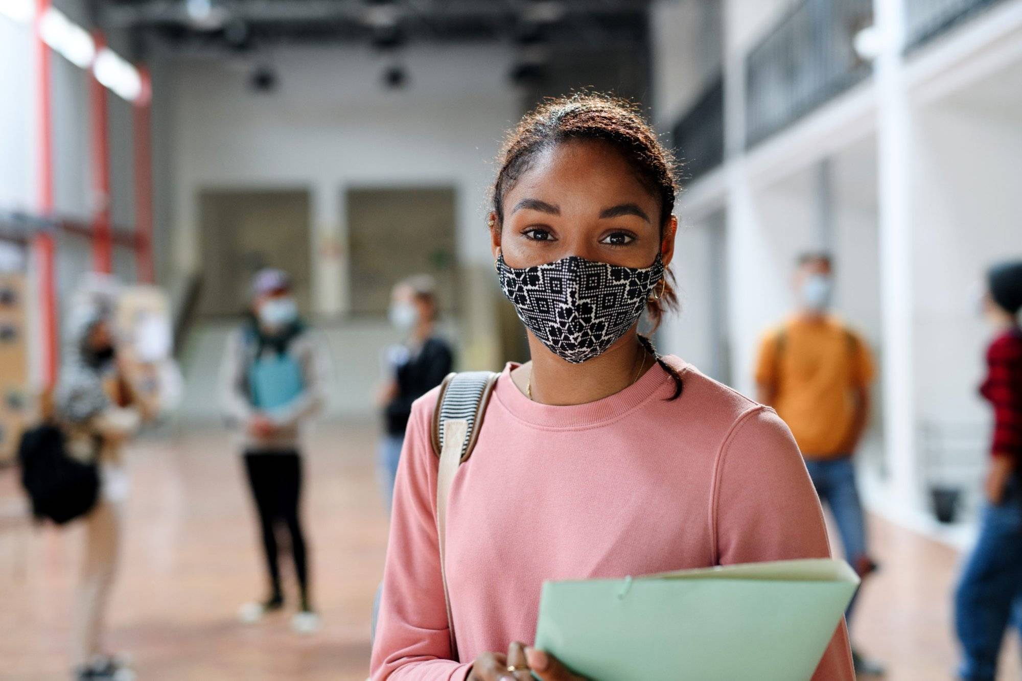 African-american student with face mask back at college or university, coronavirus concept. African-american student with face mask back at college or university, coronavirus concept.