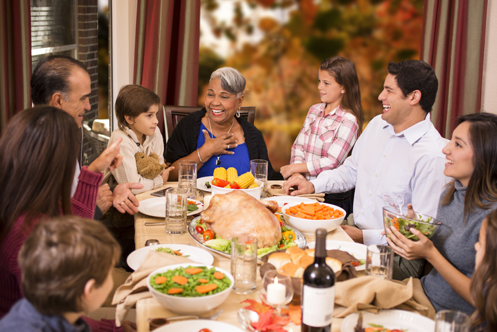 Multi-ethnic family enjoying Thanksgiving dinner at grandmother's home.